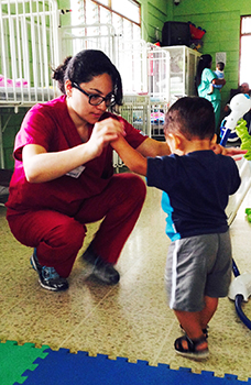 Physical Therapy student helps small child in Costa Rica.